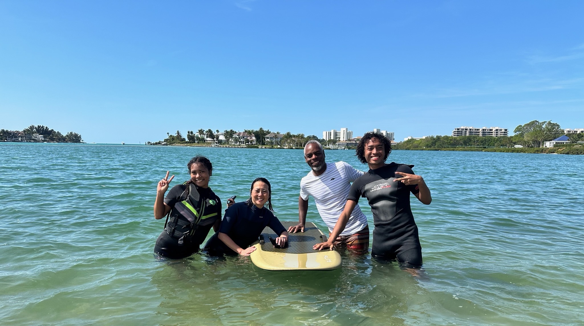 A family posing in the warm Sarasota waters with their Fliteboard
